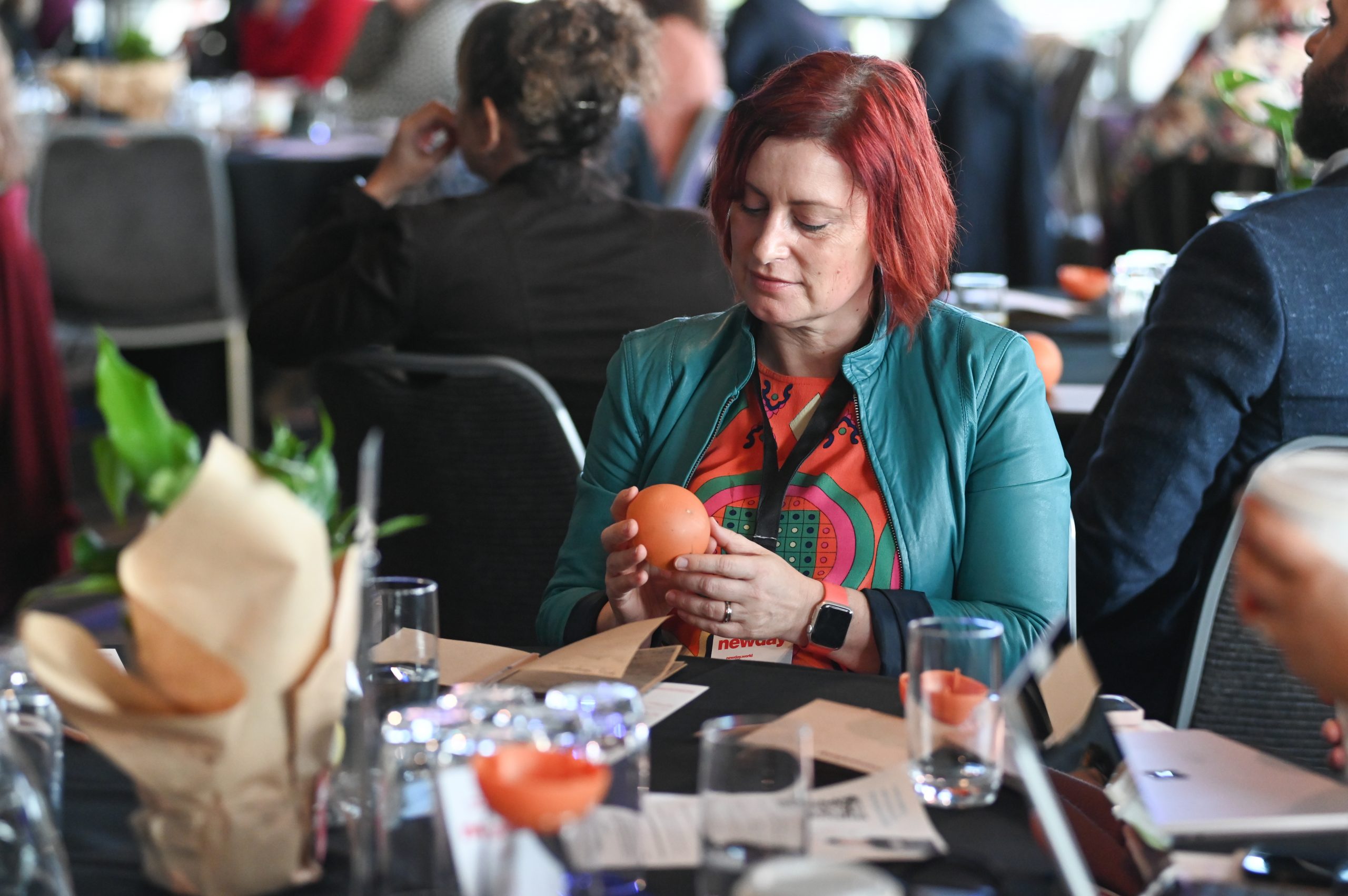 Person at table looking intently at orange sphere