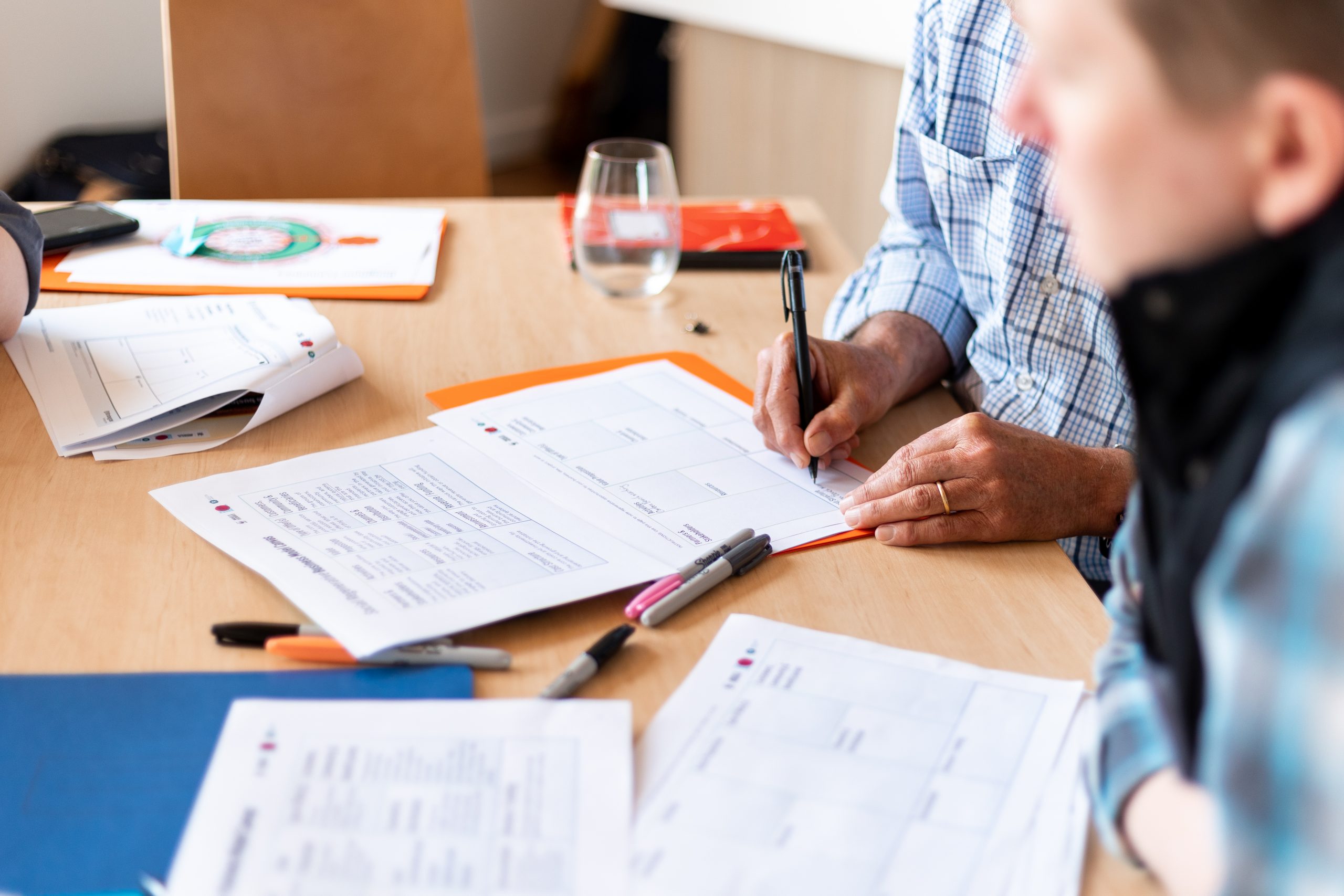 People workshopping with documents and worksheets at a table